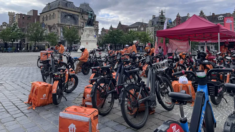 Een grote groep Takeaway-Thuisbezorgd fietsen bij een stakingspost