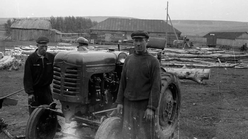 Twee boeren op een kolchoz in de Sovjet-Unie met een DT-14 tractor