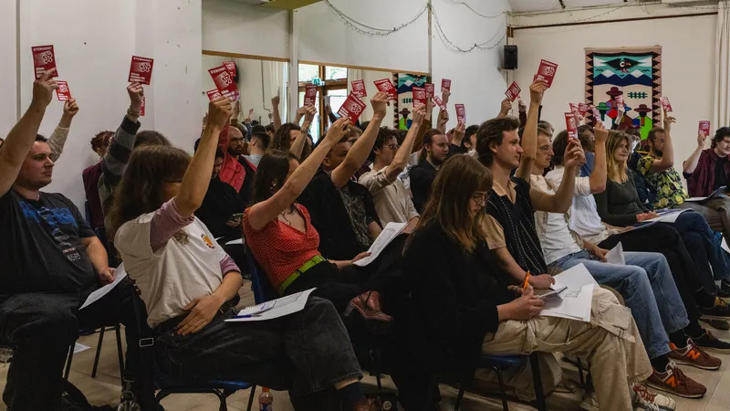 Gedelegeerden voor de conferentie houden hun stemkaart omhoog.
