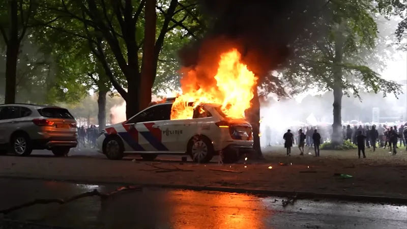 Een politieauto op het Malieveld is in brand gestoken door fascistische voetbalhooligans