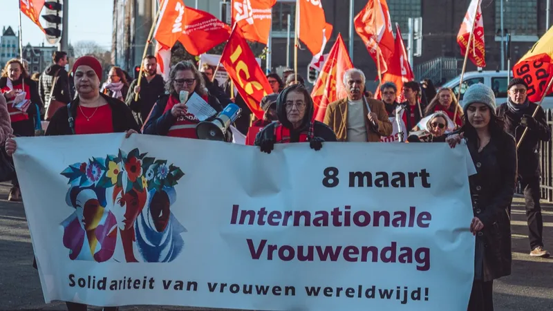 Protest op Internationale Vrouwendag in Amsterdam, 2023. Op een spandoek staat "8 maart internationale vrouwendag: solidariteit van vrouwen wereldwijd!"