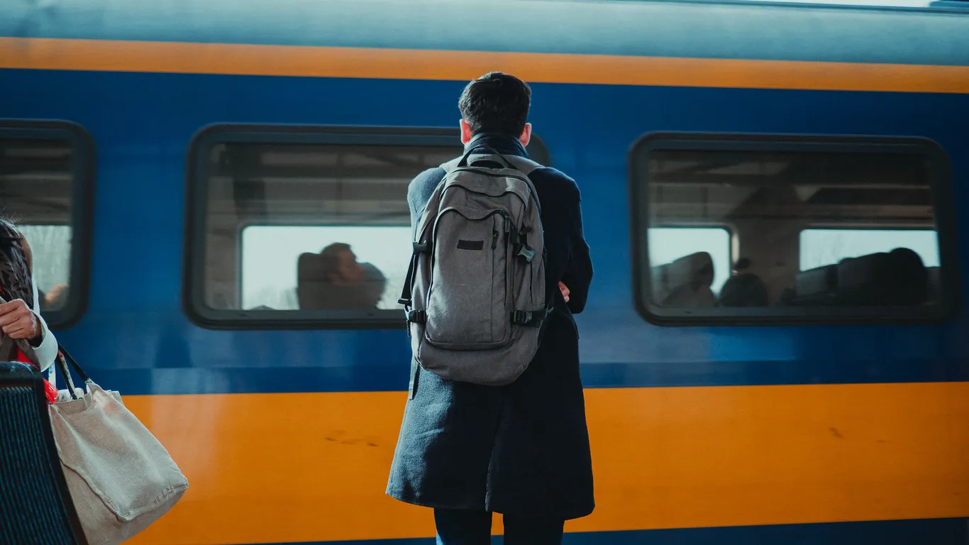 Een passagier lijkt vertwijfeld naar een NS-trein te kijken