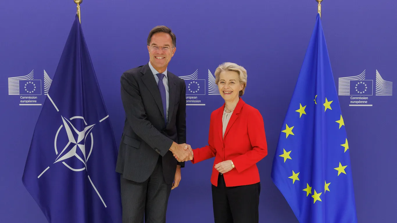 Von der Leyen wil regels ‘stroomlijnen’, maar de omnibuspakketten zijn gericht op het versterken van de oorlogseconomie en de NAVO. Op de foto geeft ze NAVO-chef Mark Rutte een hand.