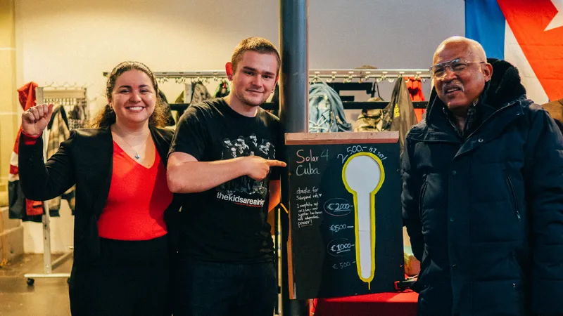 Een graadmeter waarop staat "Solar 4 Cuba" laat zien hoeveel geld er is ingezameld: €3000. Een jonge man wijst hier trots naar, links daarnaast een ambassadeur van Cuba met haar vuist omhoog.
