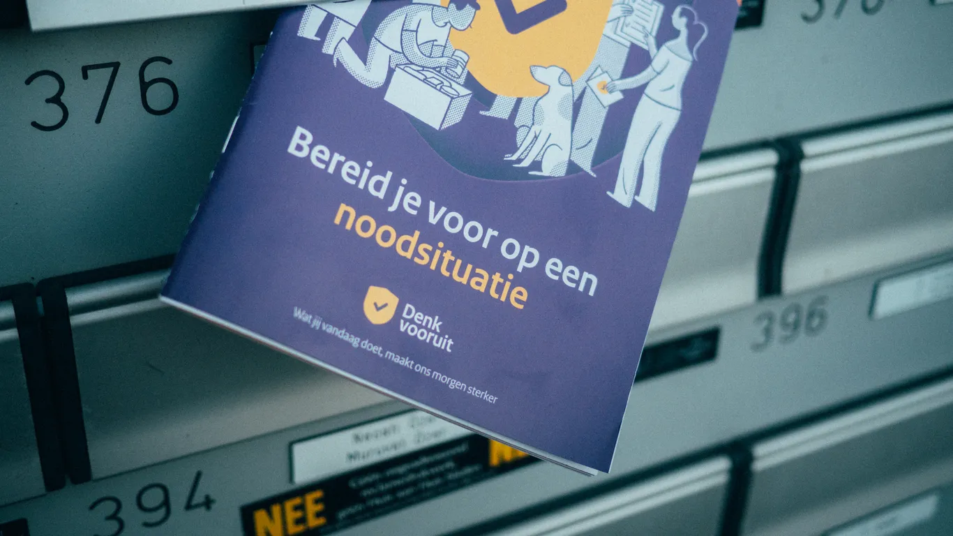 Het boekje 'Bereid je voor op een noodsituatie' steekt uit een brievenbus