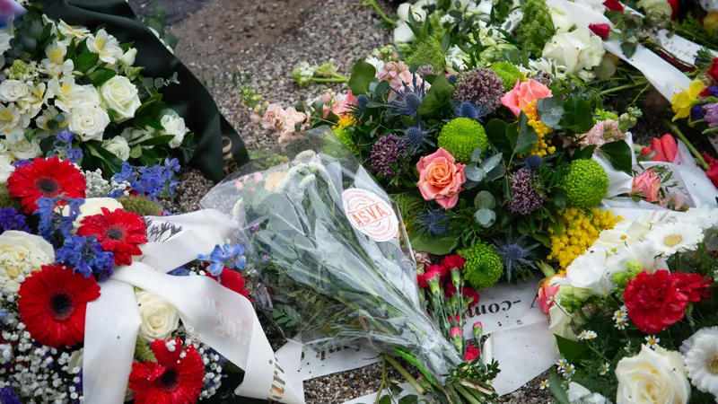 Bloemen van ASVA Studentenvakbond bij het standbeeld van de Dokwerker