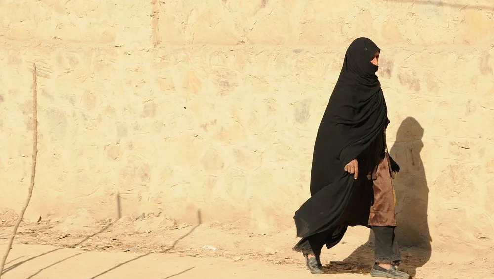 Een gesluierde vrouw loopt over straat