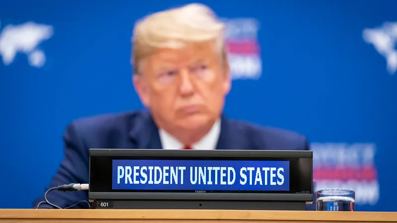 Donald Trump zit achter een bordje waarop staat "President United States"