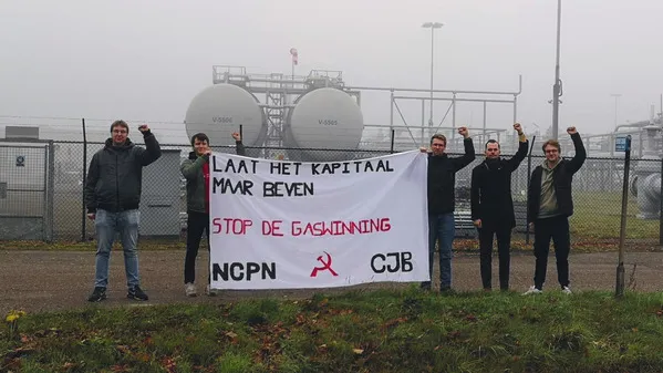 Activisten staan voor een gascentrale in groningen met een banner waarop staat "Laat het kapitaal maar geven: stop de gaswinning!"