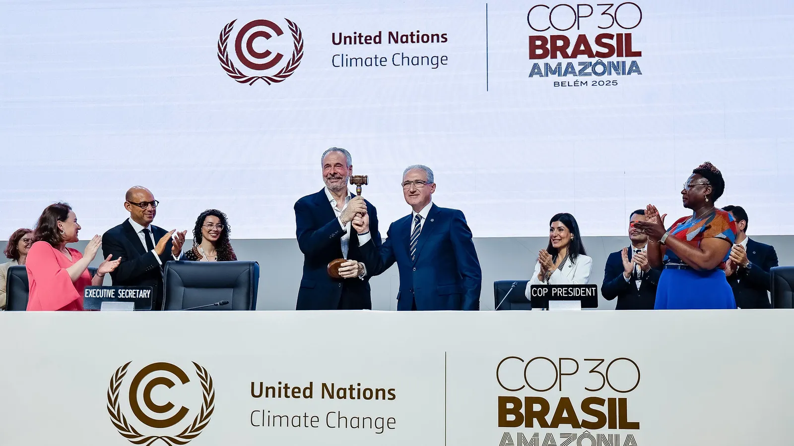 De president en secretaris van de klimaattop in Brazilië houden een hamer omhoog bij de opening van de conferentie