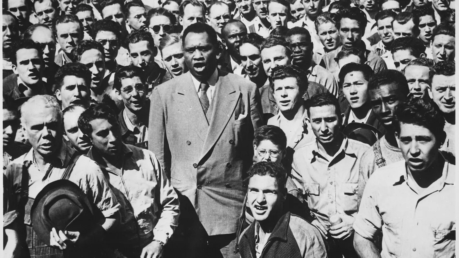 Robeson (midden, in pak) zingt samen met scheepsbouwers in Oakland in 1942 het lied The Star Sprangled Banner. De bas-bariton werkte tijdens WO I ook in de scheepsbouw.