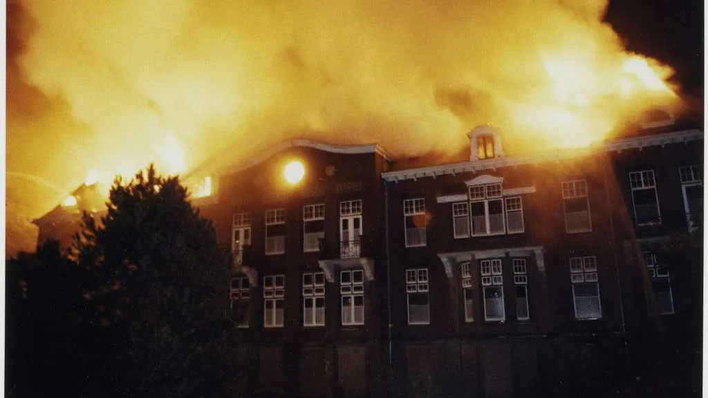 Een rij huizen staat in de brand