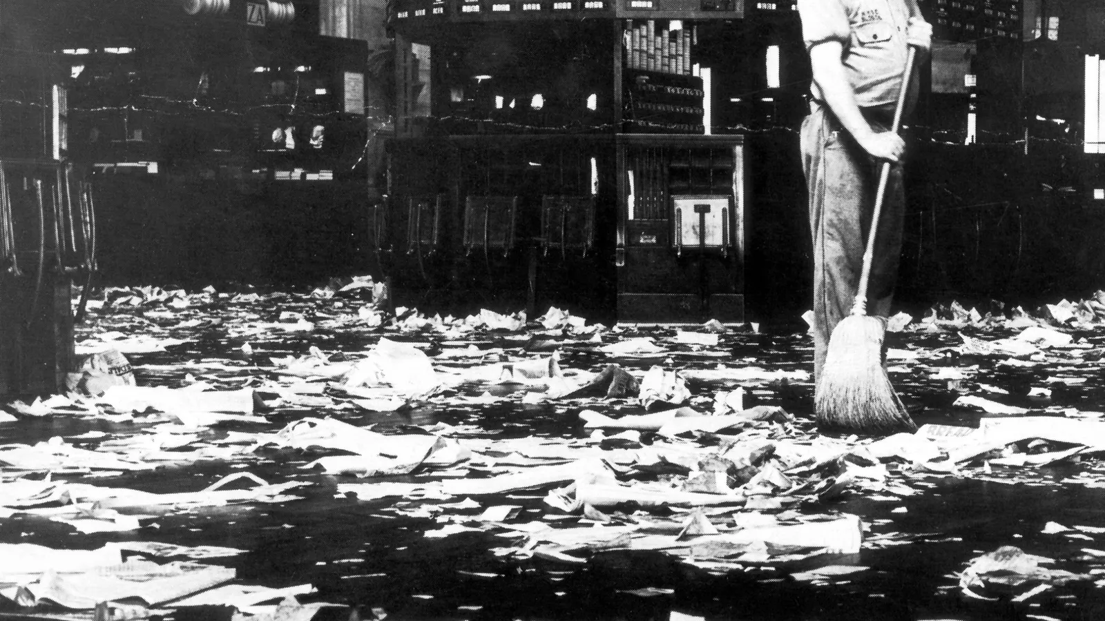 Een schoonmaker veegt de beursvloer na Zwarte Donderdag in 1929; een gebeurtenis die onder andere zou leiden tot hevige bezuinigingen in Nederland.