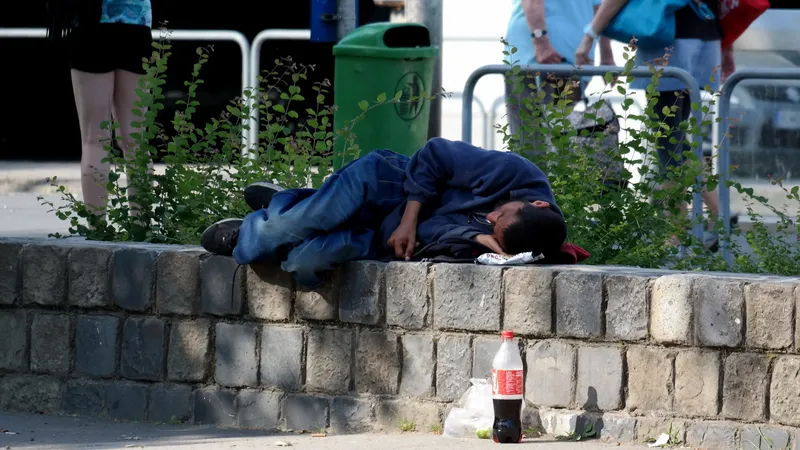 Een mogelijk dakloze man ligt te slapen op een muurtje